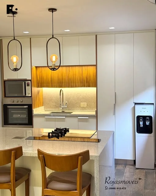 Cocina con frente de melamina blanca, listones de madera y barra desayunador