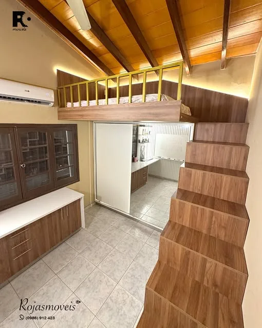 Dormitorio juvenil con cama elevada, escalera de madera con guardado y placar de puertas de vidrio