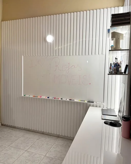 Escritorio a medida con pizarra de vidrio sobre panel blanco ranurado