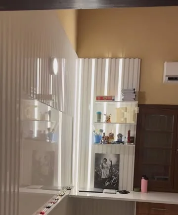 Panel blanco ranurado con estantería y placar, en un dormitorio terminado